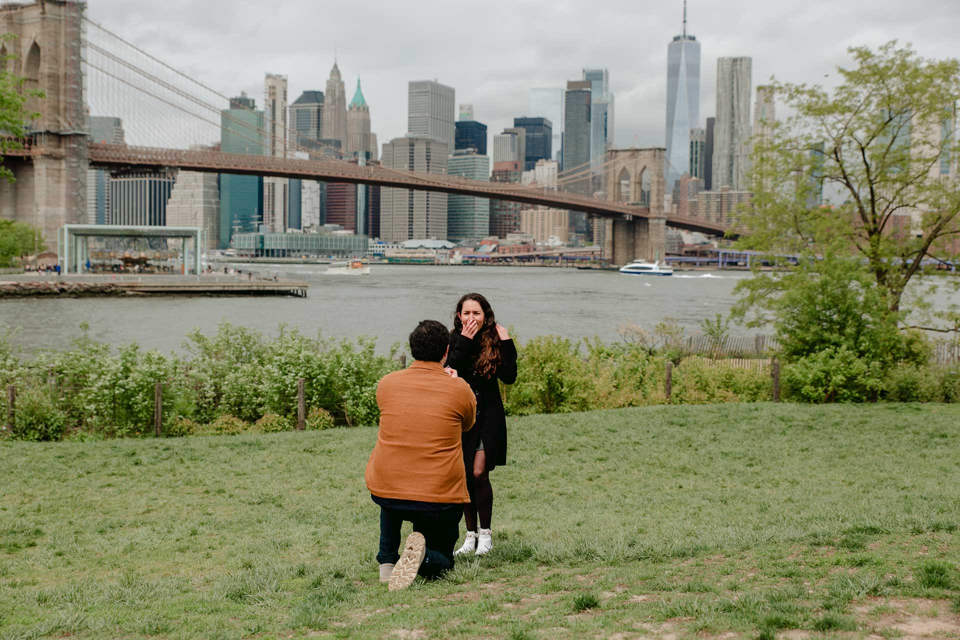surprise proposal session at dumbo park with manhattan in the background